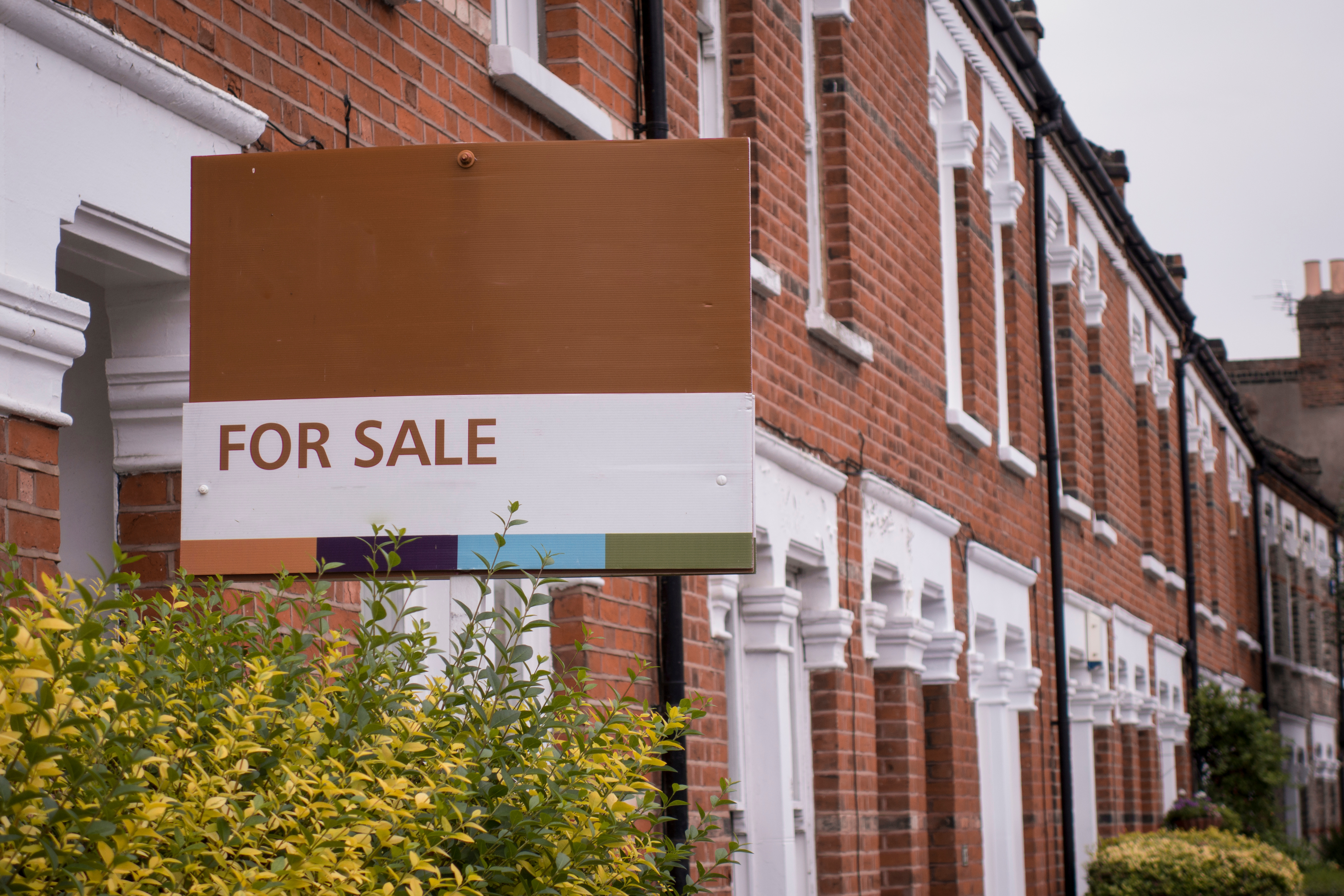 A generic for sale sign outside a terraced property