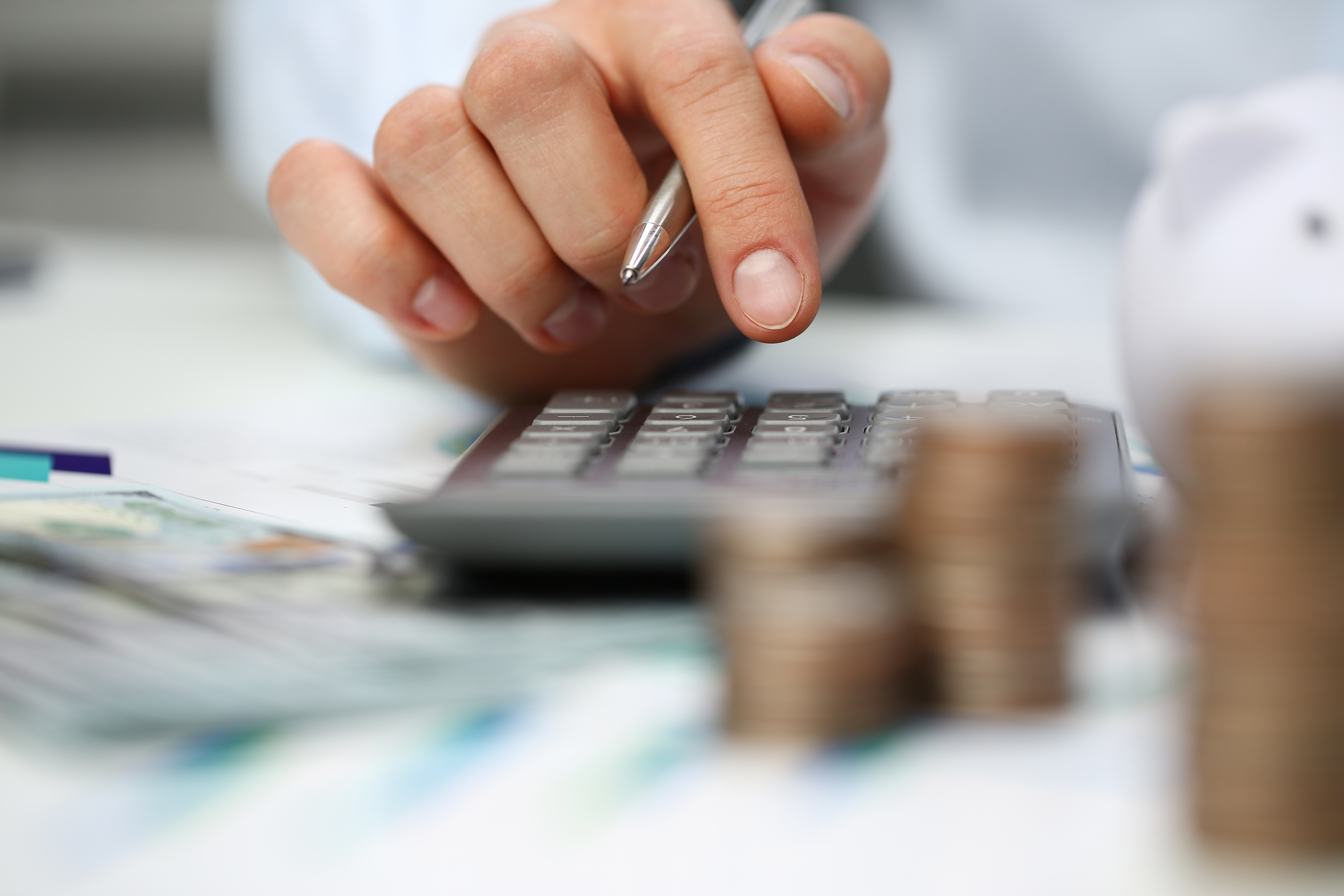 A person adding up numbers on a calculator
