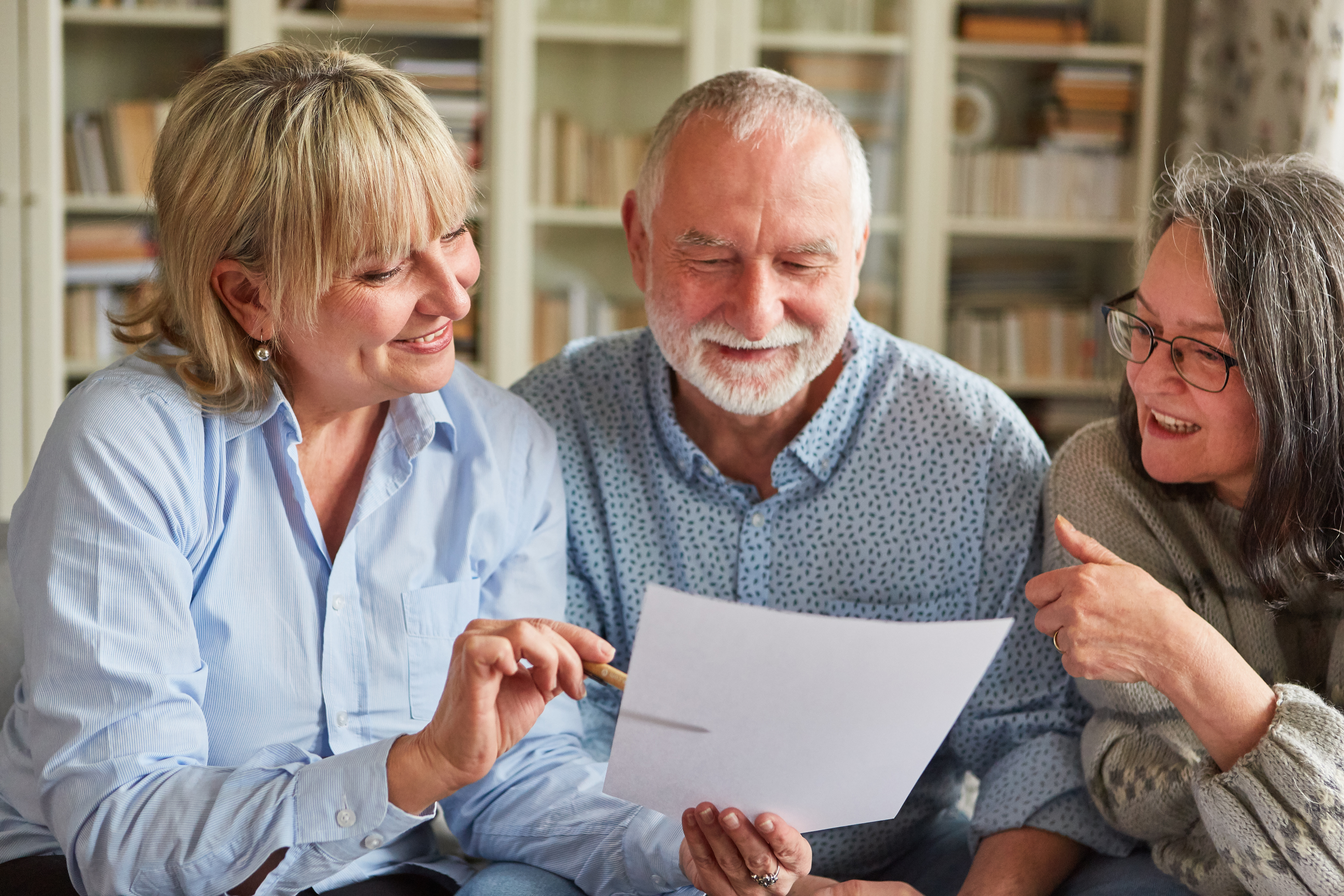 Three people gather around to discuss a document