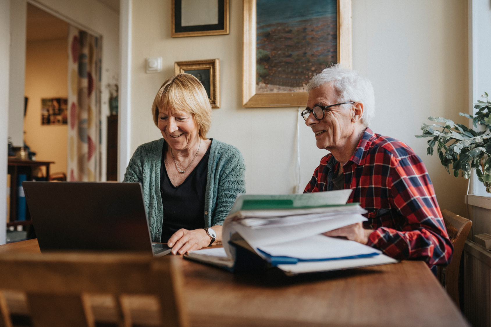 A couple at the dining table doing admin