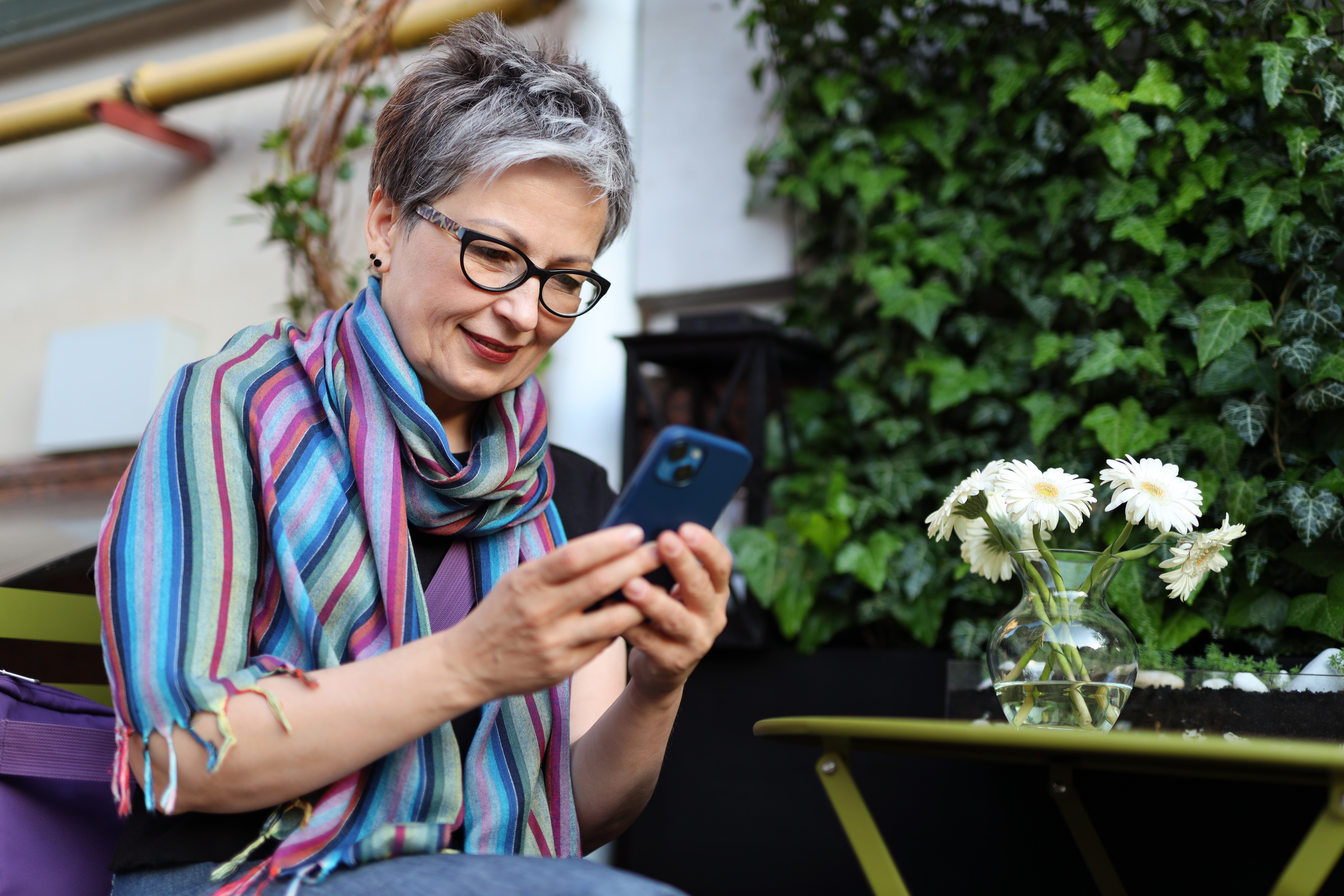 Older person on mobile phone in garden