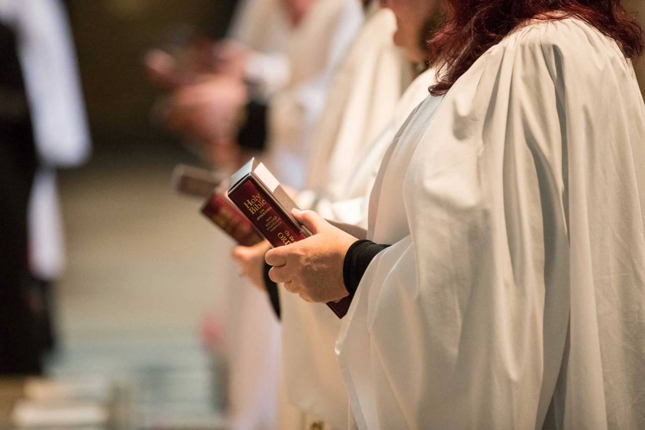 Female clergy holding a bible during an ordination service