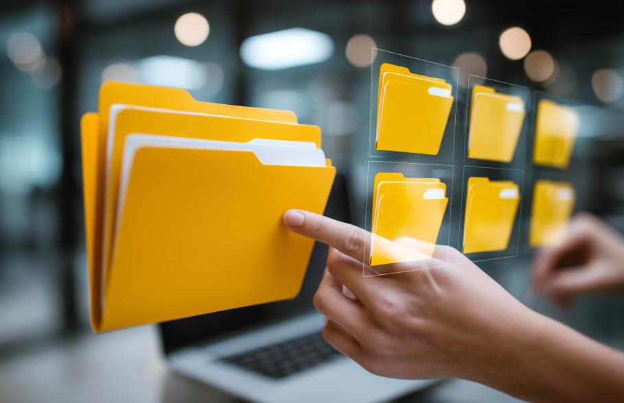 A person points as a graphic of a computer folder against a backdrop of a laptop and office