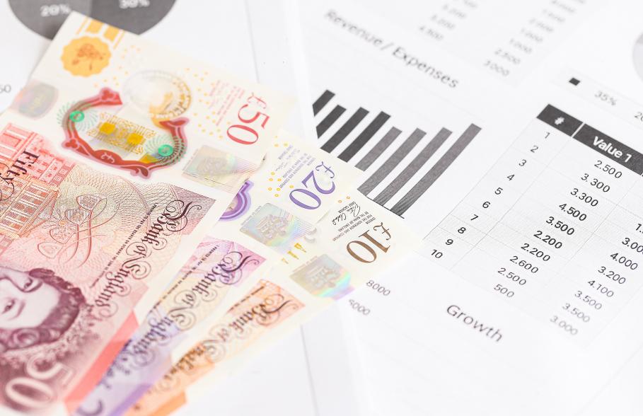 British bank notes beside a document showing a bar graph