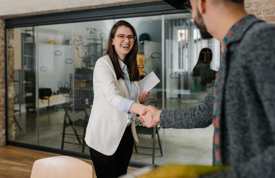 An employer welcomes a new employee with a handshake