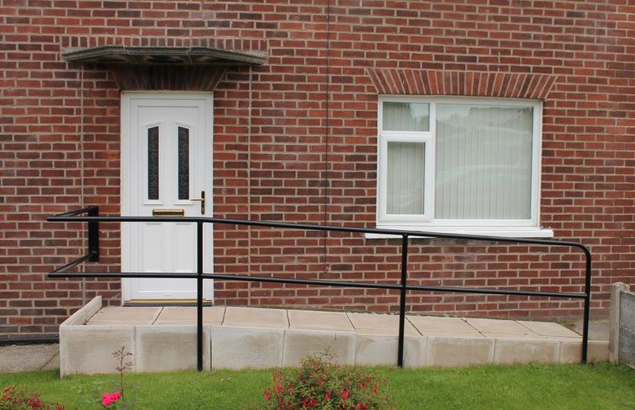 Wheelchair access ramp leading to front door of a house