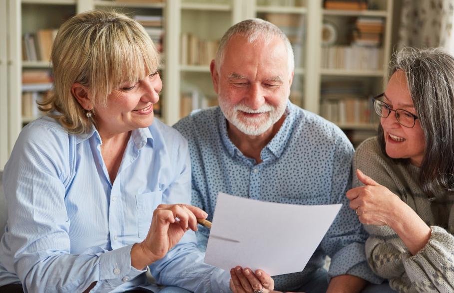 Three people gather around to discuss a document