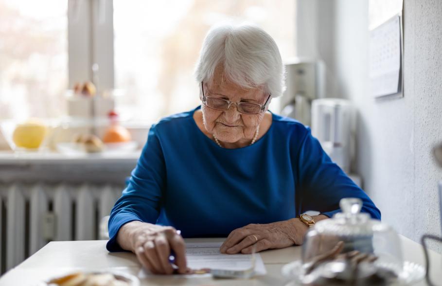 A woman sitting in her kitchen doing paperwork