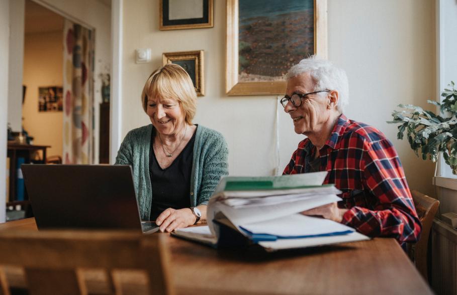 A couple at the dining table doing admin