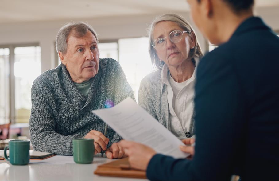 A couple listen to an advisor in a meeting at their home