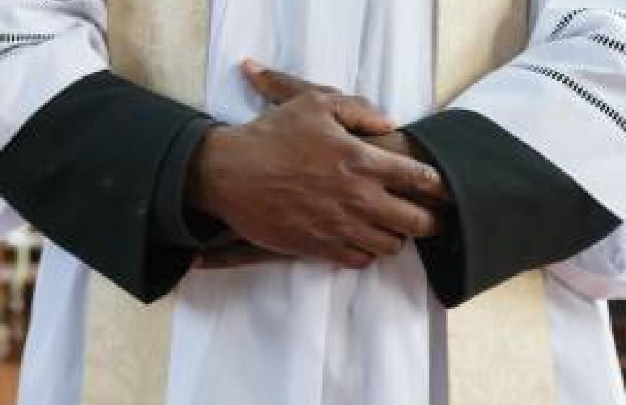 A member of the Clergy with their hands on top of each other