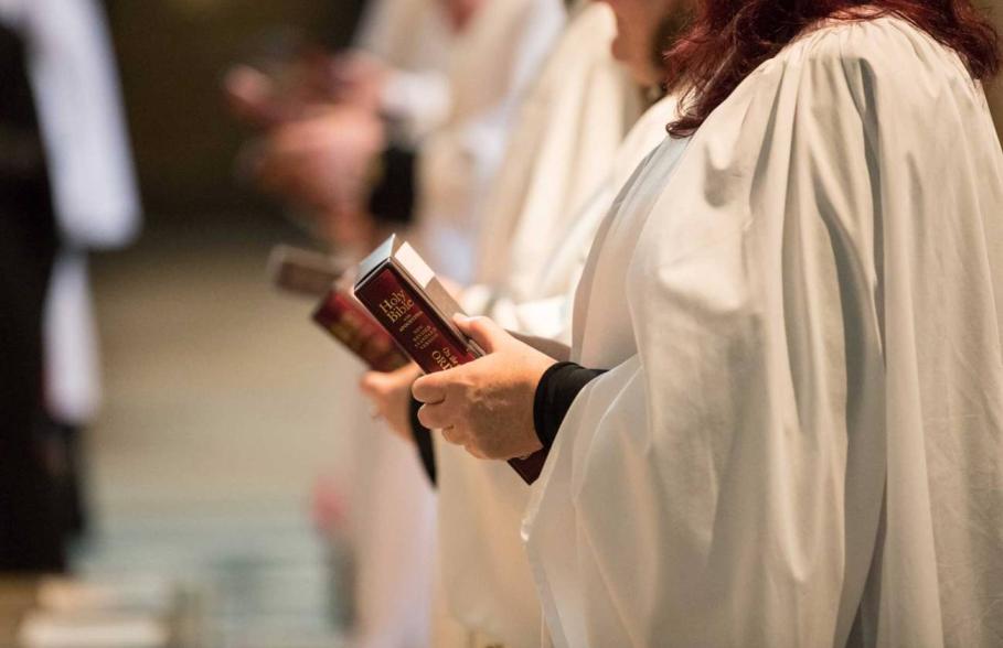 Female clergy holding a bible during an ordination service