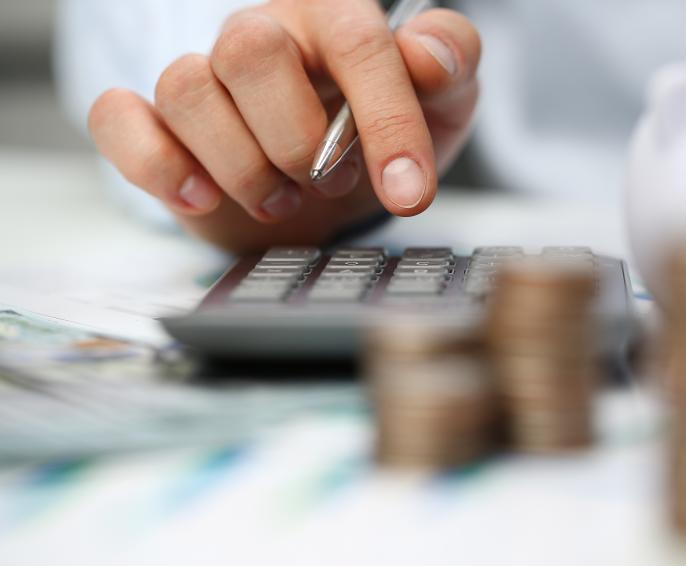 A person adding up numbers on a calculator