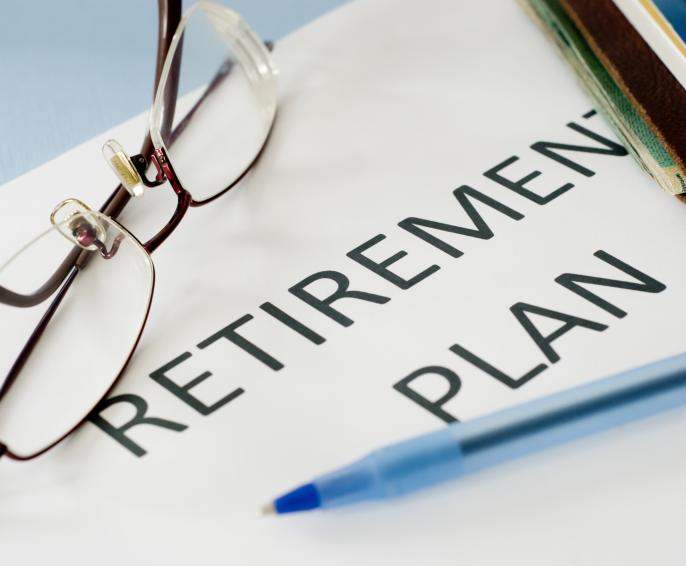 A document with the words 'Retirement Plan' with glasses and a pen