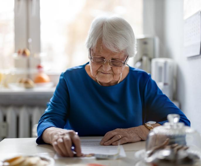 A woman sitting in her kitchen doing paperwork