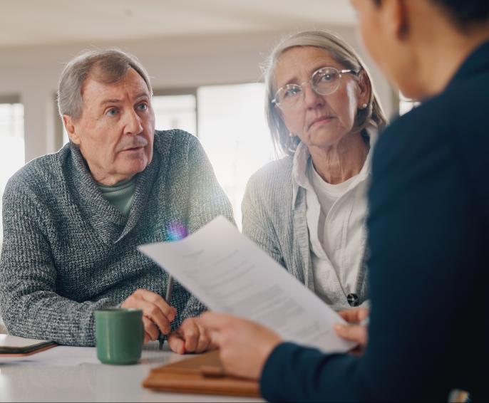 A couple listen to an advisor in a meeting at their home